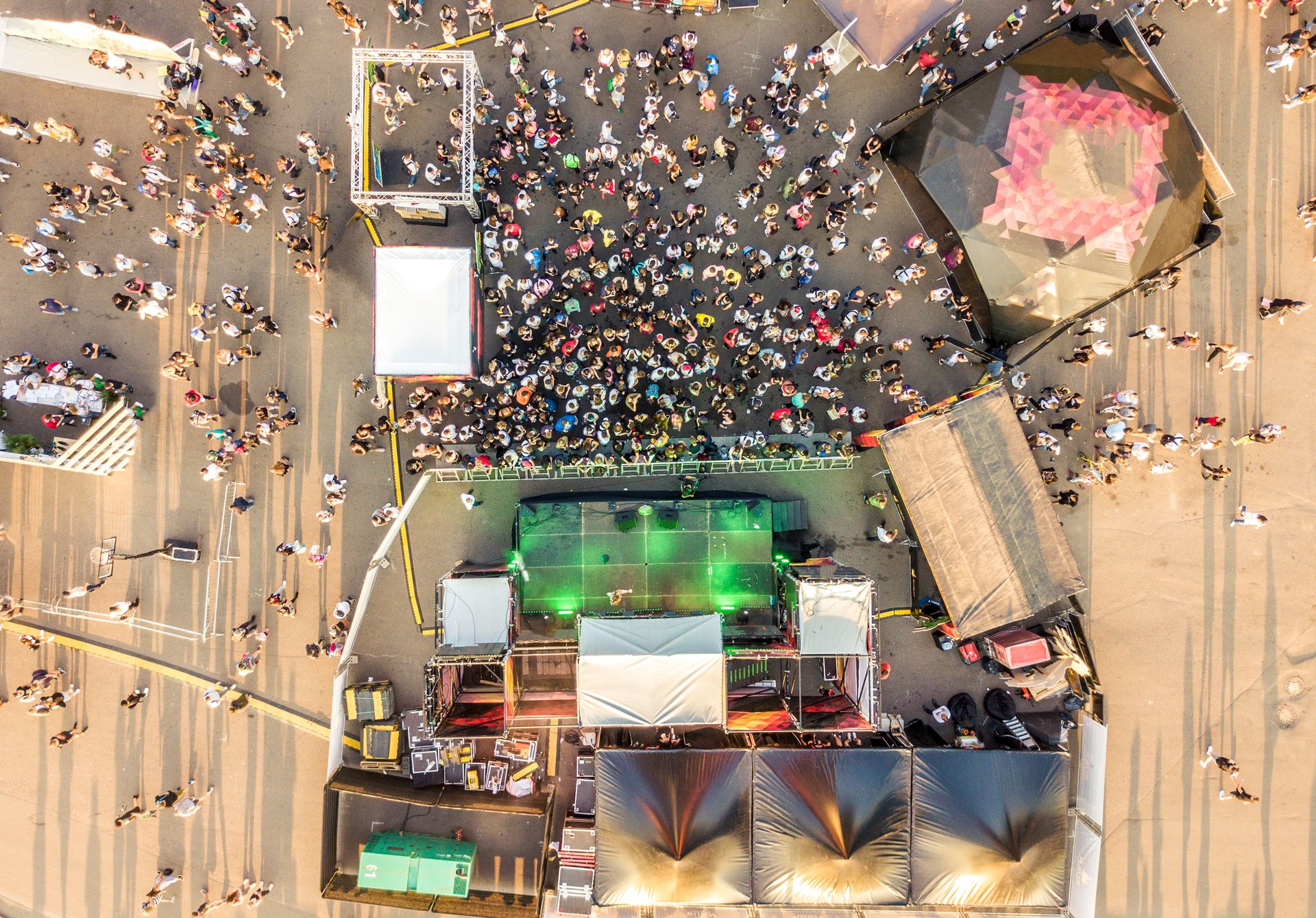 aerial top view of crowd of people standing near the stage on concert on summer day